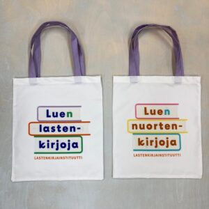 Kaksi valkoista kangaskassia, joista toisessa on teksti Luen lastenkirjoja, toisessa Luen nuortenkirjoja.